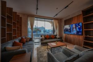 a living room with two couches and a tv at Belmar Inn Apartments in Jazan
