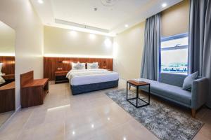 a hotel room with a bed and a couch and a window at Belmar Inn Apartments in Jazan +37 photos