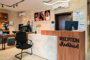 a reception desk with a chair in a room at Belmar Inn Apartments in Jazan