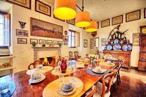 a dining room with a table and chairs and a fireplace at Il Principe by PosarelliVillas in Marsiliana