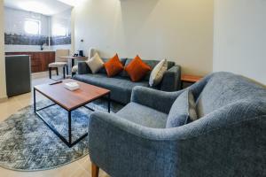 a living room with two couches and a table at Belmar Inn Apartments in Jazan
