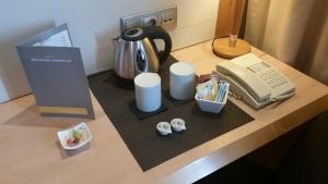 una macchinetta del caffè e un telefono su una scrivania di Hotel Barcelona Universal a Barcellona