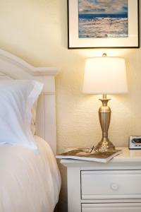 a bed with a table with a lamp on a night stand at Atlantic Hideaway in Delray Beach