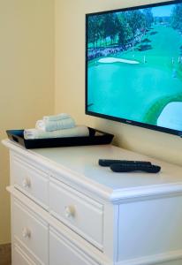 a white dresser with a television on top of it at Atlantic Hideaway in Delray Beach