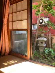 a window with a view of a garden outside at Guesthouse Namaste in Kanazawa
