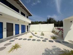 a house on the beach with a sandy yard at Ahiva Suites Goidhoo in Fehendhoo
