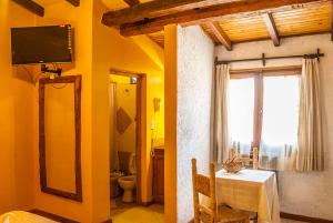 a room with a table and a bathroom with a window at Tico Tico Apart in Mina Clavero