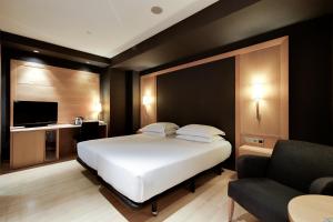a bedroom with a large white bed and a couch at Hotel Barcelona Universal in Barcelona +82 photos