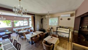 a restaurant with tables and chairs and chandeliers at International Inn in Paraćin