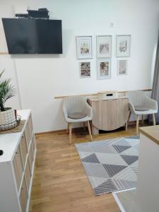 a living room with two chairs and a tv on the wall at Studio SIESTA in Vrnjačka Banja