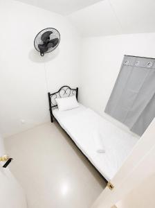a small white room with a bed in it at Sparrow Transient Townhouse in Davao City