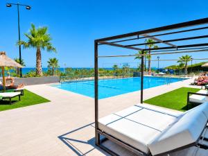 a pool at a resort with a bed and chairs at Beachfront Luxury Apartments by NRAS in Arenales del Sol +28 photos