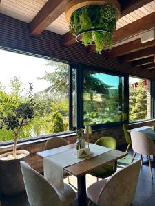 a dining room with a table and chairs and a large window at Complex Turistic Creanga Resort & Spa in Târgu Ocna