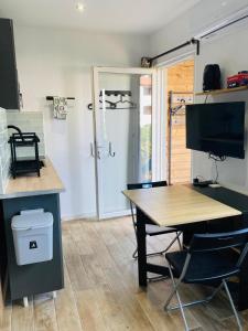 a kitchen with a table and a desk with a tv at Appart'Hotel au Pradet in Le Pradet