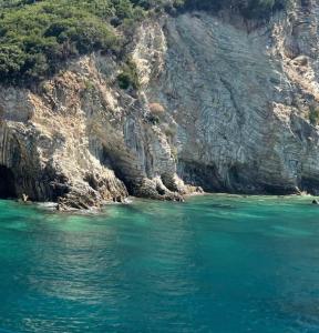 a body of water next to a rocky cliff at Sofia Comfort Apartment in Nivicë