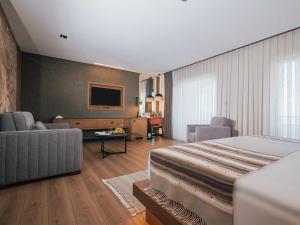 a hotel room with a bed and a living room at Panagia Premier Trabzon in Trabzon