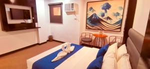 a bedroom with a bed and a painting on the wall at Huddle Room Drive Inn Motel in Angeles