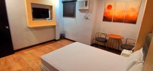 a room with a bed and a table and a tv at Huddle Room Drive Inn Motel in Angeles