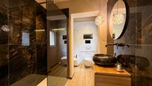 a bathroom with a sink and a glass shower at Almantra Rooms - Valle dei Templi e Mare in Favara