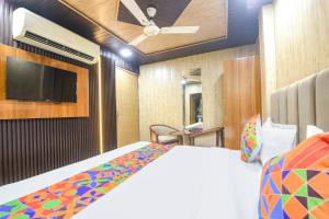 a bedroom with a bed and a flat screen tv at Via The Akshardham Bliss - LAXMI NAGAR METRO in New Delhi +25 photos
