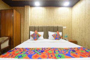 a bedroom with a large bed with a colorful comforter at Via The Akshardham Bliss - LAXMI NAGAR METRO in New Delhi