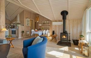 a living room with a blue couch and a stove at Awesome Home In Ulfborg With Wifi in Ulfborg