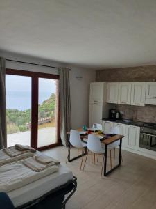 a bedroom with a bed and a kitchen with a table and chairs at Villa Maris in Nebida