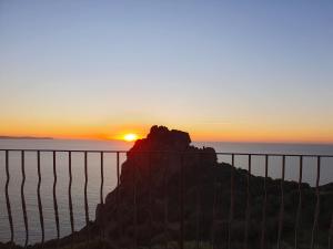 a sunset over the ocean with a fence at Villa Maris in Nebida +33 photos