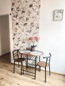 a table and chairs in a room with a flower wall at Perłowy in Biłgoraj +4 photos