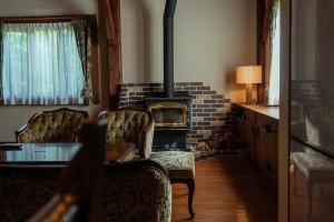 a living room with a wood stove and chairs at 山あいの静かなログハウス Quiet Mountain Log House with Indoor Hot Spring Bath in Gujo