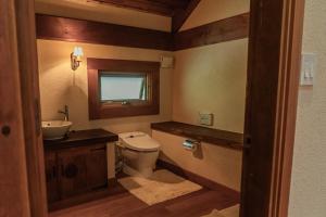 a bathroom with a toilet and a sink at 山あいの静かなログハウス Quiet Mountain Log House with Indoor Hot Spring Bath in Gujo +58 photos
