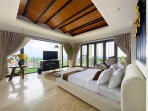 a bedroom with a large bed and a large window at Depari Dago Villa in Bandung