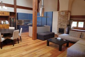 a living room with a table and a kitchen at 山あいの静かなログハウス Quiet Mountain Log House with Indoor Hot Spring Bath in Gujo