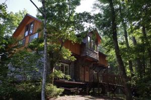 a log cabin in the woods with trees at 山あいの静かなログハウス Quiet Mountain Log House with Indoor Hot Spring Bath in Gujo