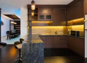 a kitchen with brown cabinets and a counter top at Depari Dago Villa in Bandung