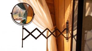 a mirror next to a window with a curtain at Nomad by Hora cu Brazi in Zărneşti
