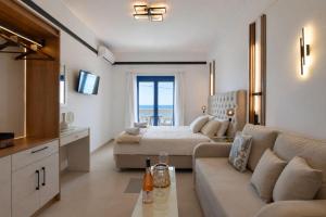 a living room with a couch and a bed in a room at Ocean View Rooms in Paralia Vrachou
