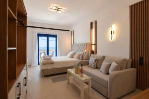 a living room with a couch and a bed at Ocean View Rooms in Paralia Vrachou