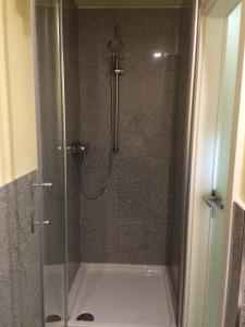 a bathroom with a shower with a glass door at Business Gästehaus Sonne, Mond & Sterne in Bremen +40 photos