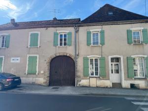 an old house with green shutters and a door at L'hotel de ville in Chéroy +3 photos