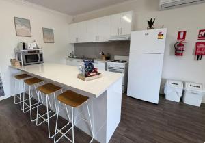 a kitchen with a white refrigerator and bar stools at Roantree House in Portland