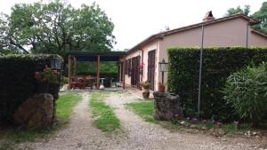 un ingresso al giardino di una casa con siepe di Agriturismo Castellum Aquarum a Poggio Murella