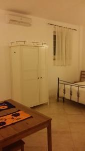 a room with a bed and a cabinet and a table at Monolocale Lori in Montefalco