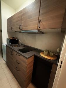 eine Küche mit Holzschränken und einer Arbeitsplatte in der Unterkunft The Seven in Reggio nell'Emilia