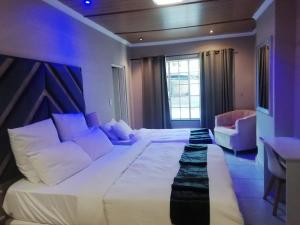 a bedroom with a large white bed and a desk at B&P Guesthouse in Boksburg +139 photos