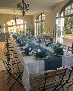 a long long table with chairs and plates and napkins at Villa 2 Pas Sages Maison de caractère au bord de la Dronne, Périgord Vert in La Roche-Chalais