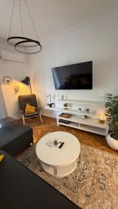 a living room with a large tv on a wall at Lemon House in Athens