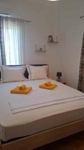 a white bed with two towels on top of it at Lemon House in Athens