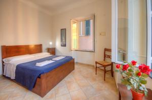 a bedroom with a bed and a chair and flowers at Club Nautico Savona in Savona