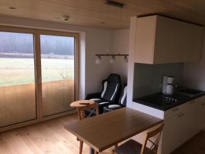 uma cozinha com uma mesa e uma cadeira num quarto em Haus Katharina em Schnepfau